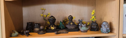a number of clay tea pets setting on a shelf