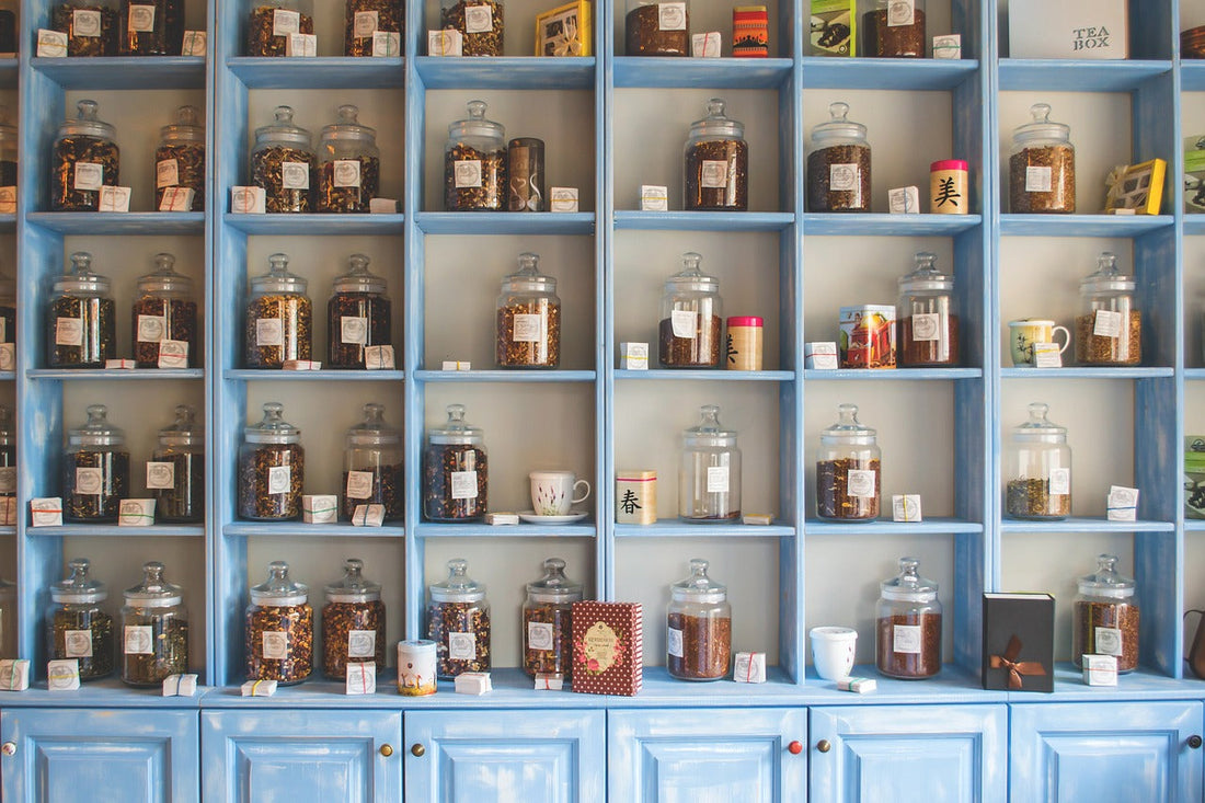 blue shelves above blue cabinets with the shelves holding glass bottles of herbs